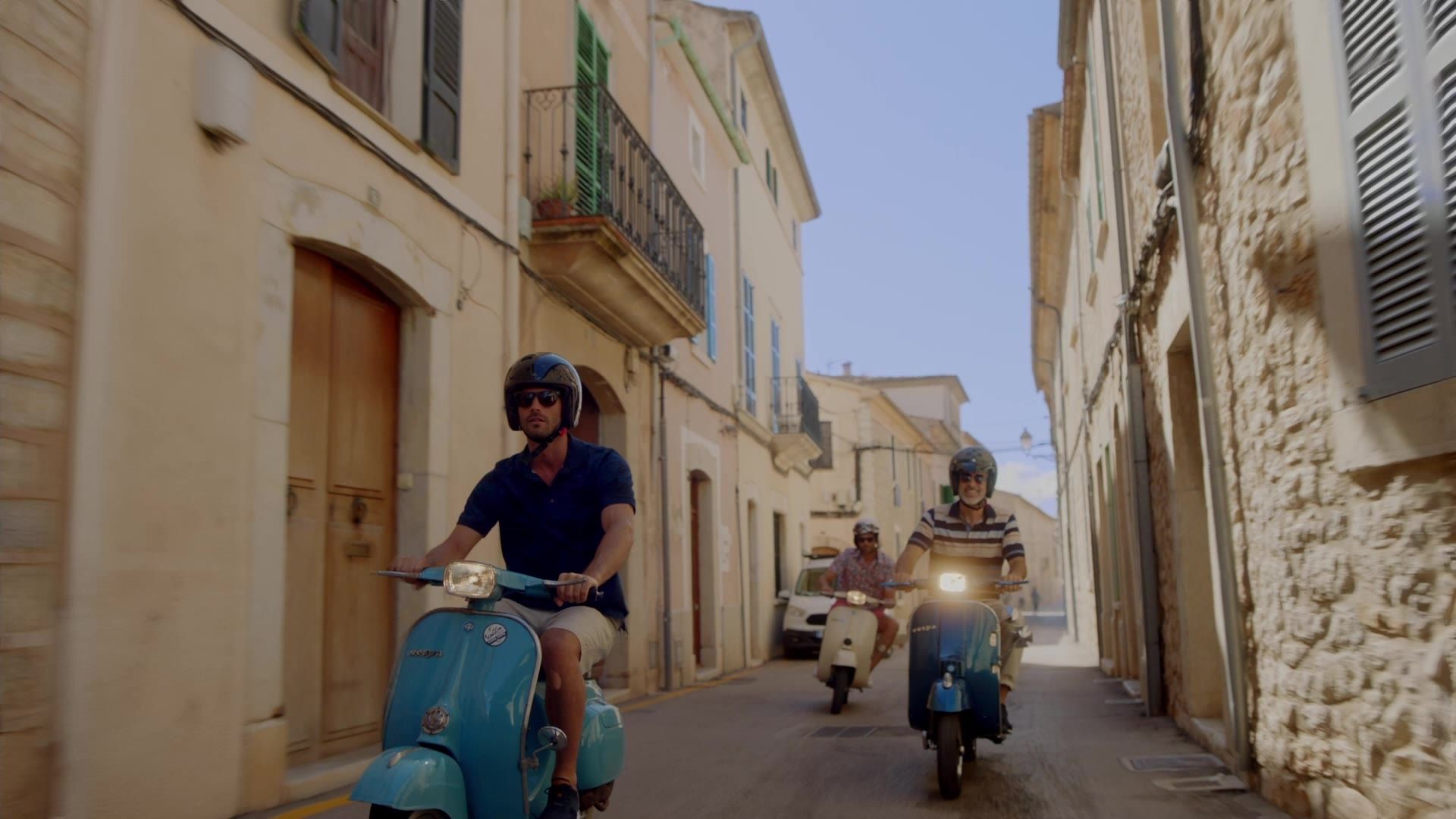 Still from the Babista film: two men on scooters in a Mediterranean street