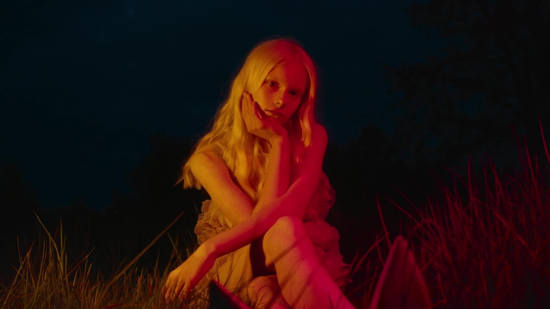 Still from the fashion film »A Cord Unbroken« for Elle Ukraine: a woman lit in red at night